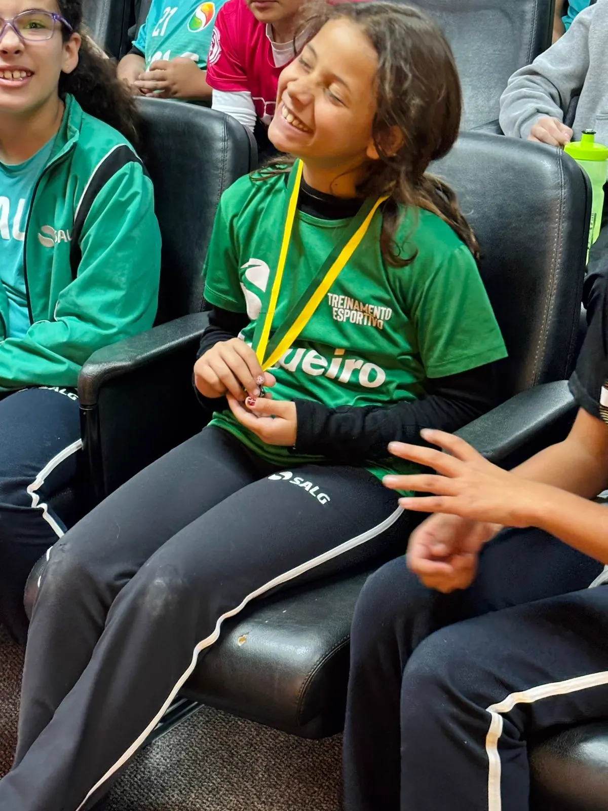 Aluna sorrindo com a medalha da Olimpíada Canguru nas mãos