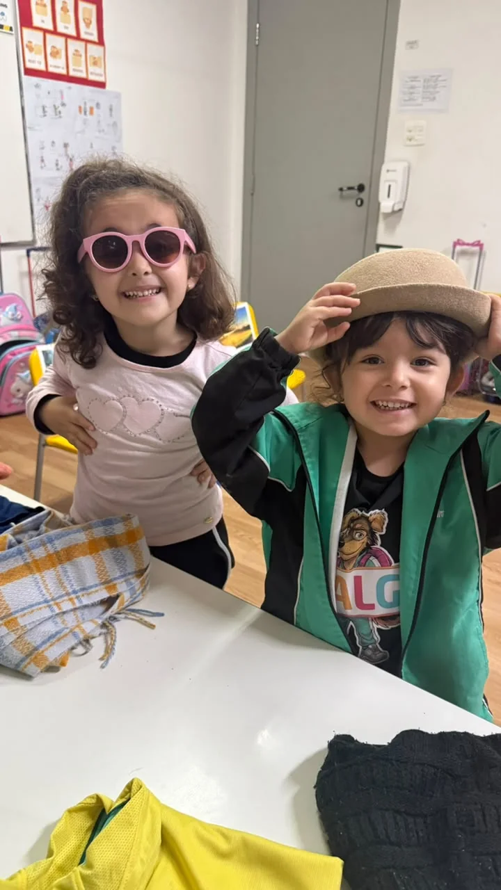 Crianças escolhem roupas e acessórios para a previsão do tempo em inglês