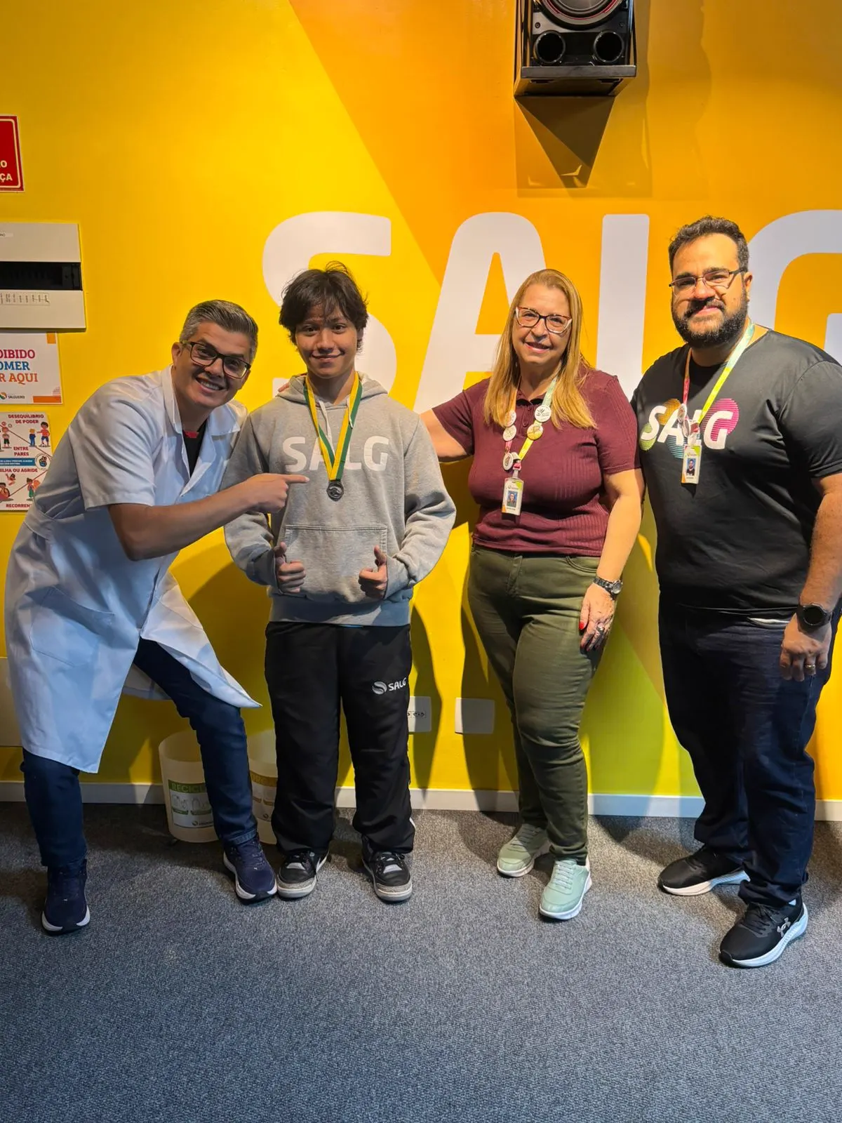 Aluno premiado ao lado de educadores do Colégio Salgueiro
